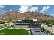 Grand modern home with a luxurious pool and basketball court set against a mountain backdrop at 5814 E Camelback Rd, Phoenix, AZ 85018