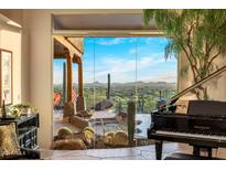 Bright living room with floor to ceiling windows and grand piano at 6001 E Restin Rd, Cave Creek, AZ 85331