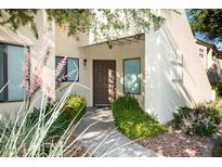 Charming front entrance featuring a wooden door, tasteful landscaping, and a welcoming walkway at 7575 E Indian Bend Rd # 1012, Scottsdale, AZ 85250