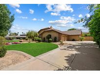 Charming single-Gathering home with a well-manicured lawn, landscaping, and a long driveway leading to an attached garage at 8272 S Pecan Grove Cir, Tempe, AZ 85284