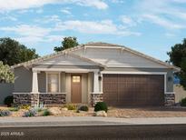 Charming single-story home with a stone-accented facade, a two-car garage, and desert landscaping at 17809 W Elm St, Goodyear, AZ 85395