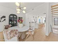 Bright dining room features a modern chandelier and seamless transition to the kitchen and staircase at 312 E Windsor Ave # 3, Phoenix, AZ 85004