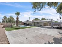Large backyard showcasing a pool, brick fire pit, covered patio and parked car at 530 E Draper St, Mesa, AZ 85203