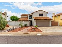 Charming two-story home featuring a desert landscape, two-car garage, and red tile roofing at 5407 W North Ln, Glendale, AZ 85302