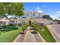 Inviting home with a red door, lush lawn, and beautiful landscaping in a desirable neighborhood at 645 S 54Th St, Mesa, AZ 85206