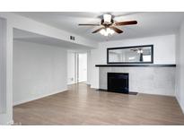 Bright living room featuring a fireplace, light wood floors, and neutral paint at 850 S River Dr # 1068, Tempe, AZ 85281