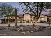 Inviting desert home featuring mature landscaping and a paver driveway at 8821 E Havasupai Dr, Scottsdale, AZ 85255
