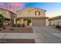 Charming two-story home featuring a well-manicured lawn, a tile roof and a two car garage at 13553 N 141St Ln, Surprise, AZ 85379