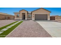 Beautiful single-Gathering home boasting desert landscaping, grey stucco exterior, and a two car garage at 14861 S Capistrano Rd, Arizona City, AZ 85123