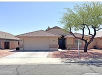 Charming single-story home featuring a tile roof, desert landscaping, and a two-car garage at 16325 W Paradise Ln, Surprise, AZ 85388