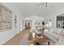 Bright, open-concept living room features a vaulted ceiling, stylish decor, and seamless flow to dining and kitchen areas at 2546 E Roma Ave, Phoenix, AZ 85016