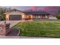 Charming single-story home featuring a well-manicured lawn, brick accents, and a two-car garage at 2726 E Hale St, Mesa, AZ 85213