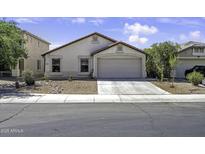Charming single-story home with a two-car garage and desert landscaping in front yard at 40845 W Thornberry Ln, Maricopa, AZ 85138