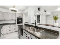 Updated kitchen features stainless steel sink, granite countertops, and white cabinets at 540 N May -- # 1075, Mesa, AZ 85201