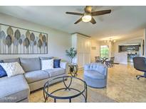 Inviting living room features a comfortable gray sectional sofa, modern decor, and seamless access to the dining area at 5950 N 78Th St # 102, Scottsdale, AZ 85250