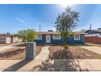 Charming single-story home with blue exterior, landscaped front yard, and a welcoming walkway to the front door at 6033 S 19Th Pl, Phoenix, AZ 85042