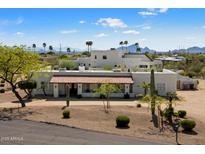 Stunning aerial view of a luxurious estate with tile roof surrounded by desert landscape and palm trees at 9224 N 126Th St, Scottsdale, AZ 85259