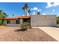 Charming single-story home featuring a desert landscape, an attached garage, and palm trees at 9629 N 83Rd Way, Scottsdale, AZ 85258