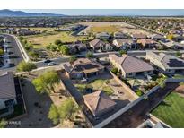 Expansive aerial view of a community home featuring a spacious backyard with a trampoline and desert landscaping at 17451 W Hadley St, Goodyear, AZ 85338
