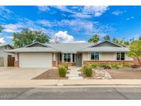 Charming single-story home with a well-maintained front yard and a two-car garage, under a partly cloudy sky at 3722 E Glade Ave, Mesa, AZ 85206