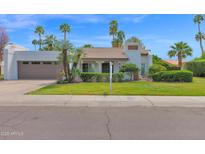 Charming home featuring a well-manicured lawn, mature palms, and a beige exterior at 8337 E Shetland Trl, Scottsdale, AZ 85258