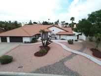 Aerial view of home with tile roof, desert landscaping, and a three car garage at 13631 N 70Th Dr, Peoria, AZ 85381