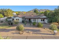 Elegant home featuring a circular brick driveway, mature desert landscaping, and mountain views at 21315 E Marsh Rd, Queen Creek, AZ 85142