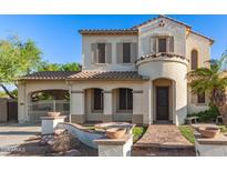 Charming two-story home featuring a stucco exterior, tile roof, and gated driveway entrance at 12911 W Campbell Ave, Litchfield Park, AZ 85340