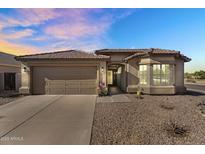 Charming home exterior with a two-car garage, low maintenance desert landscaping, and a welcoming front entrance at 17152 W Watkins St, Goodyear, AZ 85338