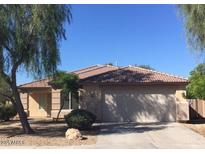 Charming single-story home featuring a red tile roof, two-car garage, and desert landscaping at 206 N 152Nd Ave, Goodyear, AZ 85338