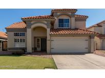 Charming two-story home with a tile roof, arched entryway, and two-car garage at 2305 E Millbrae Ct, Gilbert, AZ 85234