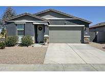 Charming single-story home features a two-car garage, a gray color scheme, and manicured landscaping at 36354 W San Clemente Ave, Maricopa, AZ 85138