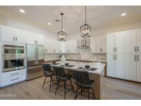 Bright kitchen features modern appliances, island seating, and stylish pendant lighting at 7296 E San Alfredo Dr, Scottsdale, AZ 85258
