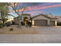 Charming single-story home with desert landscaping, two-car garage, and an inviting front entryway at 14424 N 64Th Pl, Scottsdale, AZ 85254