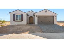 Charming single-story home with neutral stucco, arched entry, and a two-car garage with stylish gray pavers leading to the driveway at 21278 N 272Nd Ave, Buckeye, AZ 85396
