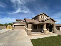 Two-story home featuring desert landscaping, tile roof, covered front porch, and a two car garage at 32157 N Caspian Way, San Tan Valley, AZ 85143