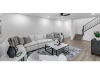 Bright living room features a modern sofa, stylish coffee table, and a staircase on the right side at 3416 N 44Th St # 51, Phoenix, AZ 85018