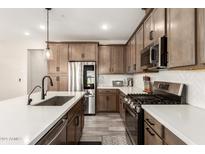 Well-lit kitchen with stainless steel appliances, stylish countertops, and gas cooktop at 759 E Lark St # 202, Gilbert, AZ 85297