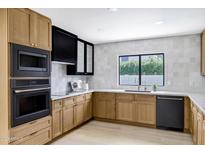 Bright kitchen featuring sleek, modern appliances, light wood cabinets, and white marble countertops at 8019 E Del Timbre Dr, Scottsdale, AZ 85258