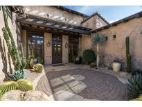 Inviting courtyard with desert landscaping, stone accents, and wooden pergola at 10057 E Blue Sky Dr, Scottsdale, AZ 85262