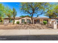 Charming single-story home featuring desert landscaping, mature trees, and a welcoming front porch at 14815 N 21St St, Phoenix, AZ 85022