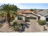 Charming home with a tile roof, desert landscaping, and a paved driveway at 18058 W Weatherby Dr, Surprise, AZ 85374