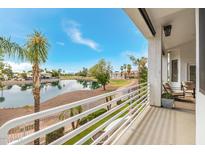 Inviting balcony view overlooking a lush green golf course and serene water feature on a sunny day at 21474 N 56Th Ave, Glendale, AZ 85308