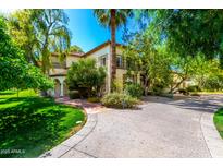 Stately two-story home with a lush green yard and a circular driveway provides instant curb appeal at 3006 N Manor W Dr, Phoenix, AZ 85014