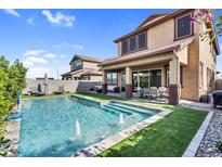 View of a pool with fountains, artificial grass, an outdoor dining area, and the home's rear elevation at 3960 E Appaloosa Rd, Gilbert, AZ 85296