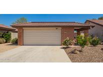 Charming single-story home featuring a brick facade, a two-car garage, and desert landscaping at 12201 S Paiute St, Phoenix, AZ 85044
