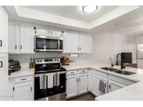 Modern kitchen features white cabinetry, stainless steel appliances, and sleek countertops at 12201 S Paiute St, Phoenix, AZ 85044