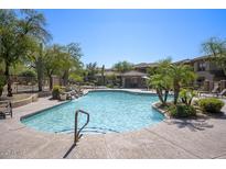 Resort-style community pool with waterfall feature, lush landscaping and comfortable lounge area at 19700 N 76Th St # 1058, Scottsdale, AZ 85255