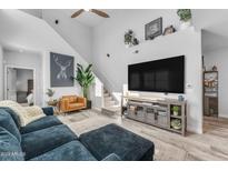 Bright living room with high ceilings, a staircase, and a large television at 2511 W Queen Creek Rd # 474, Chandler, AZ 85248