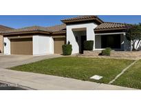 Inviting single-story home with a well-manicured lawn, a two-car garage, and a stylish, covered entryway at 702 E Capricorn Way, Chandler, AZ 85249